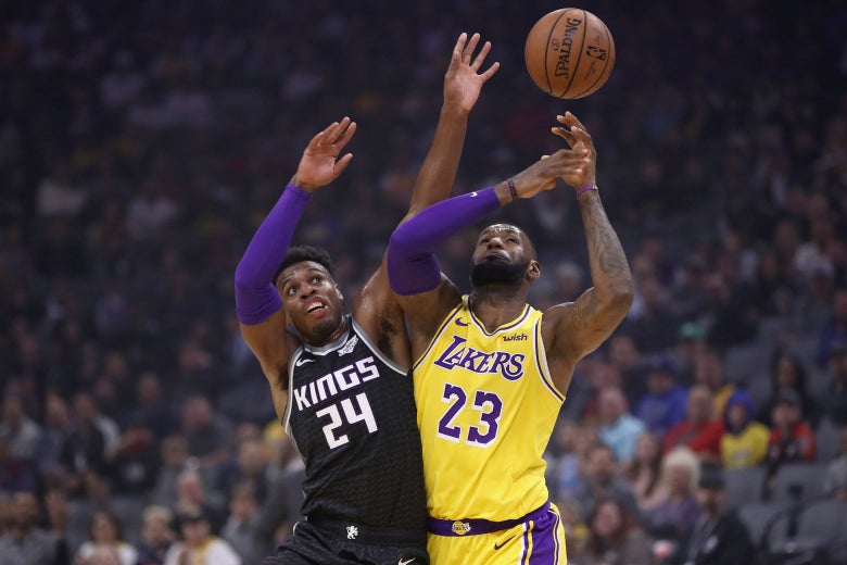 LeBron James and Buddy Hield go for the ball on Saturday at Golden 1 Center in Sacramento, California.